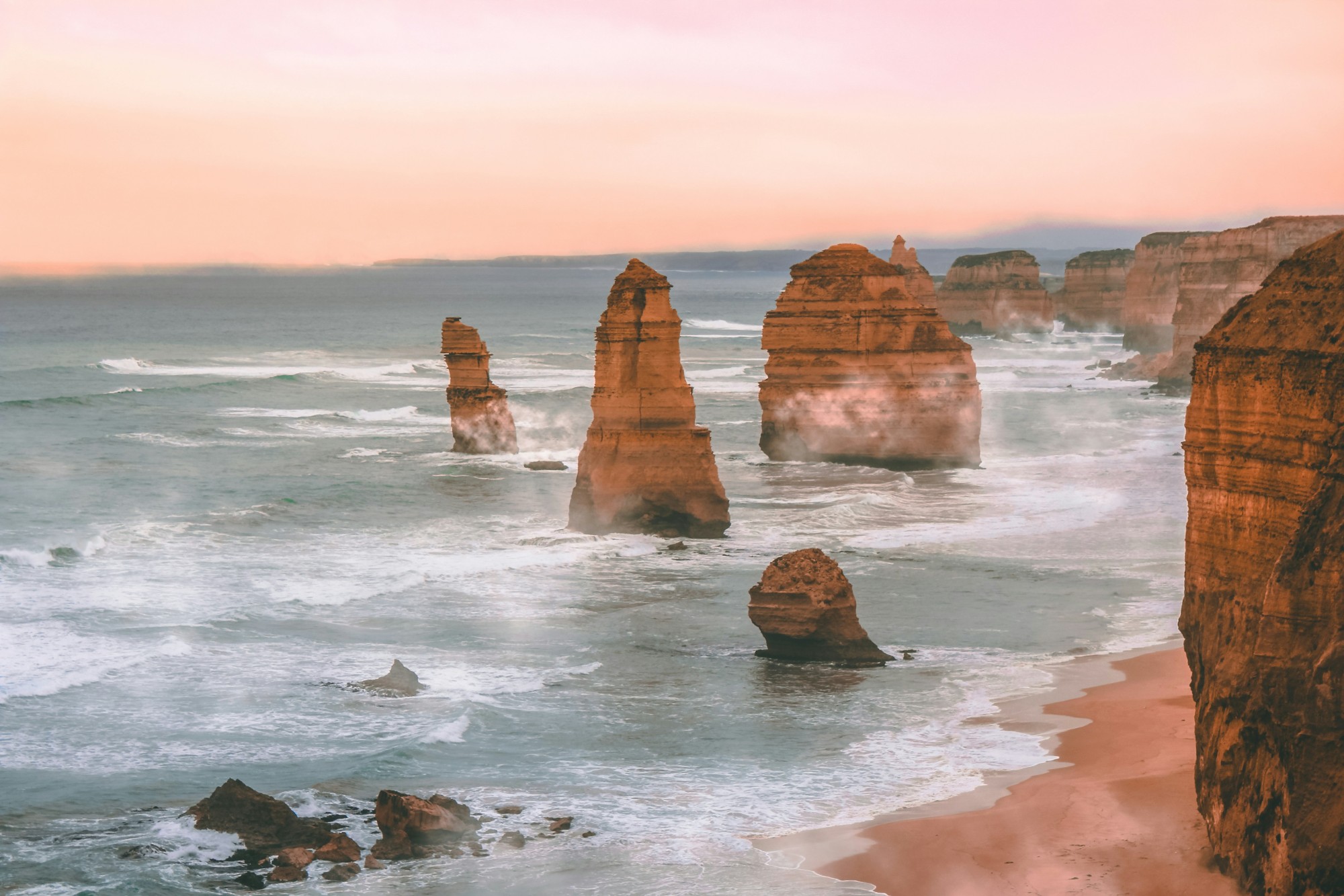 Twelve Apostles rock stacks standing in the ocean at sunset along the Great Ocean Road