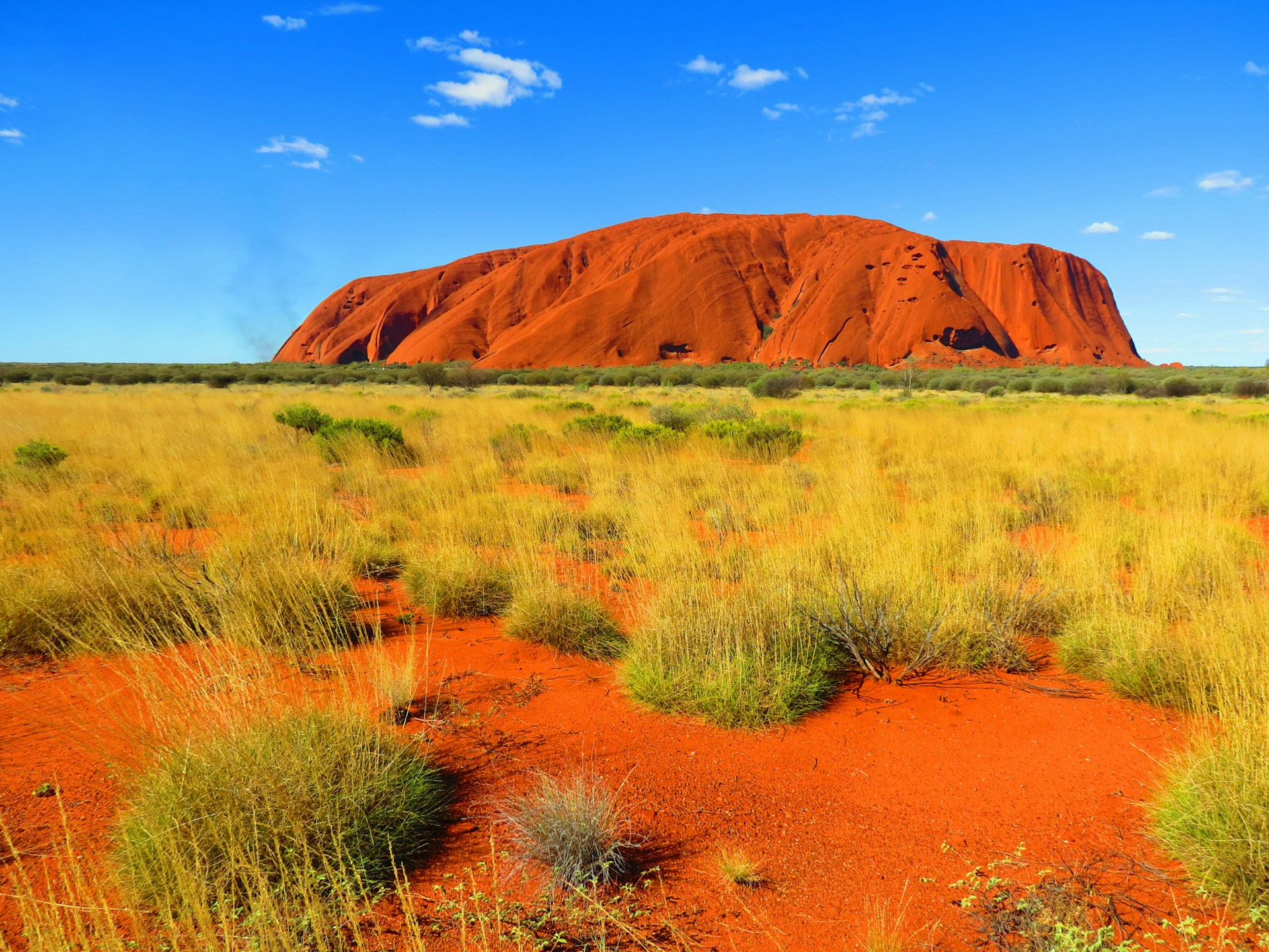Uluru at dusk under a deep orange sky in the Northern Territory